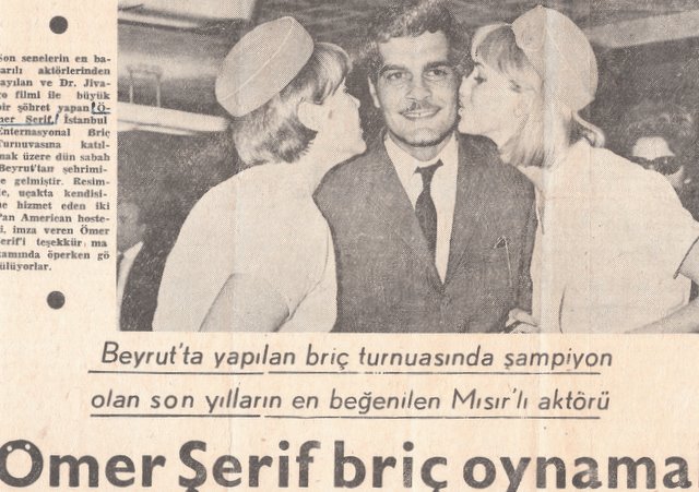 1960s Judy Skartvedt & another Flight Attendant pose for a publicity shot with actor Omar Sherif for a Turkish Newspaper.  Judy is on the right facing the photo.